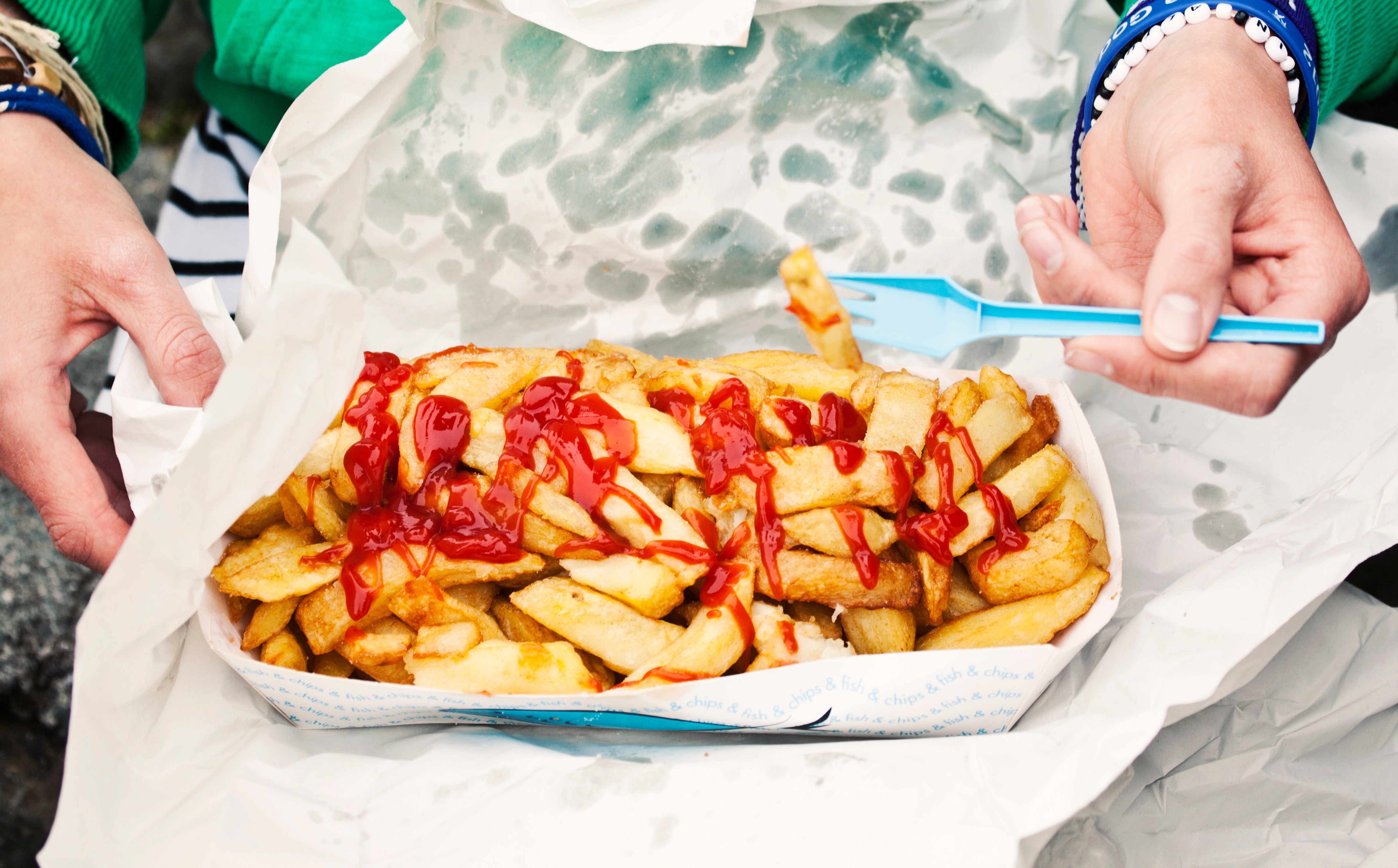 Person eating fries and ketchup.