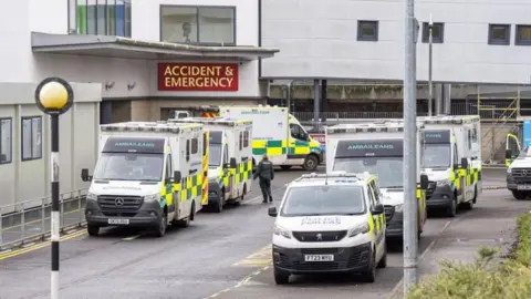 PA Media Ambulances and police vans parked outside the entrance to an accident and emergency ward at the Victoria Hospital in Kirkcaldy 