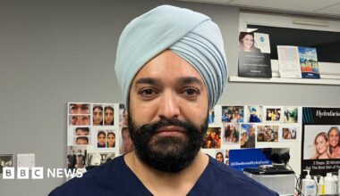 A man wearing a blue uniform, looking directly at the camera.