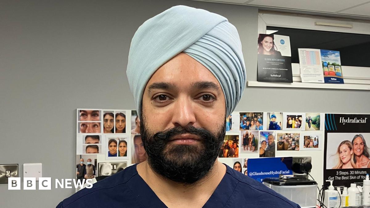 A man wearing a blue uniform, looking directly at the camera.