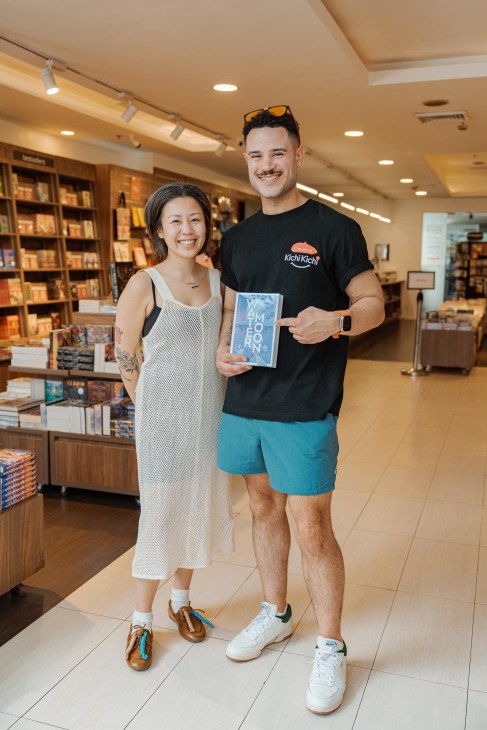 Prescilla and Taylor, a couple from Canada who like to visit local bookstores when traveling, pose for a photo with a book they purchased at the Fully Booked branch in Bonifacio High Street, Manila, Philippines, on Thursday, April 17, 2025.