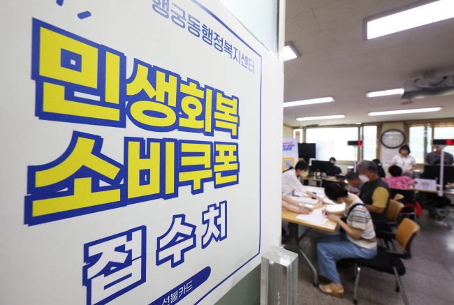 This undated file photo shows officials at a community center in Suwon, south of Seoul, preparing to accept applications for consumption coupons. (Image courtesy of Yonhap)