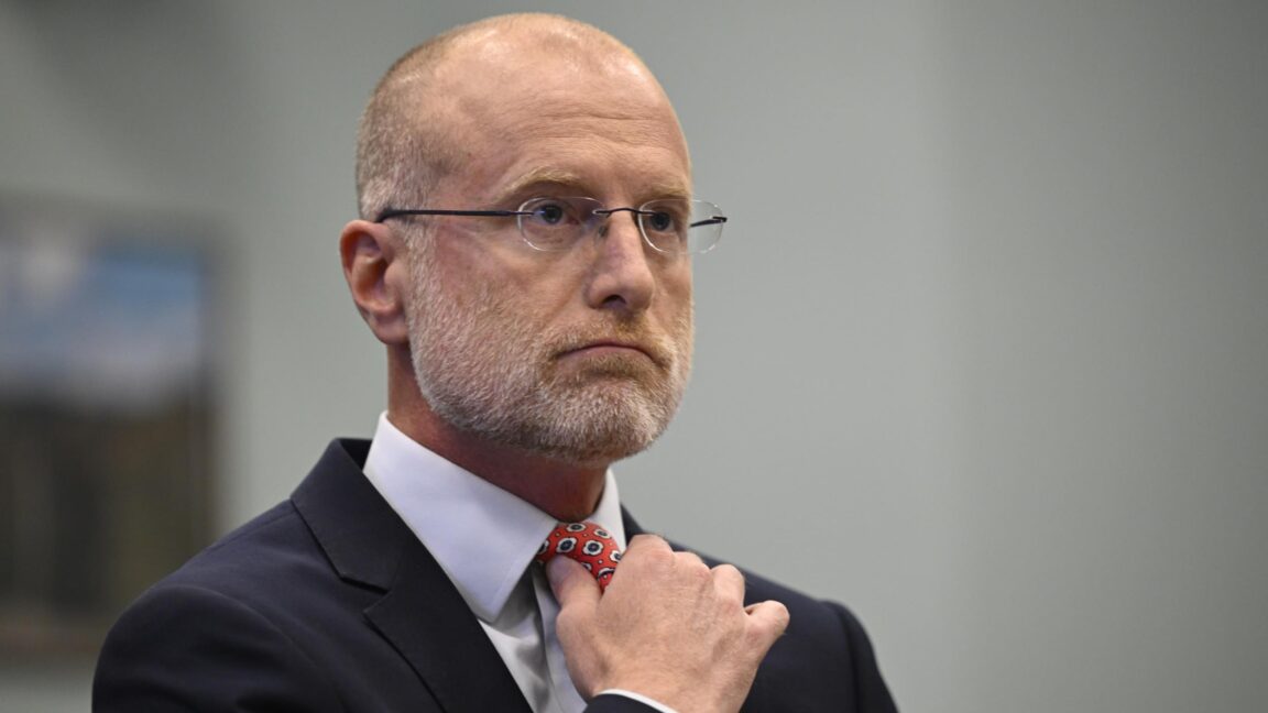 FCC Chairman Brendan Carr adjusts his tie at a Congressional hearing where he was testifying.