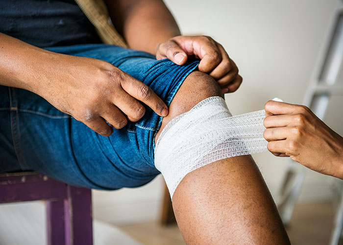 Close-up of a patient’s knee being bandaged, highlighting delayed help with shocking consequences in medical care.