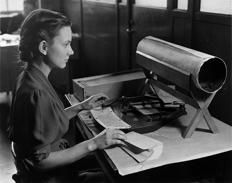 Woman operating a punched card machine