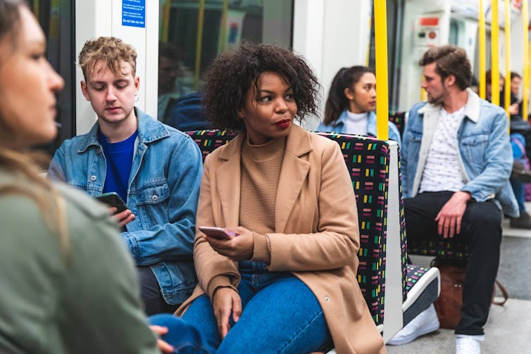Commuters looking suspiciously at someone off-camera.