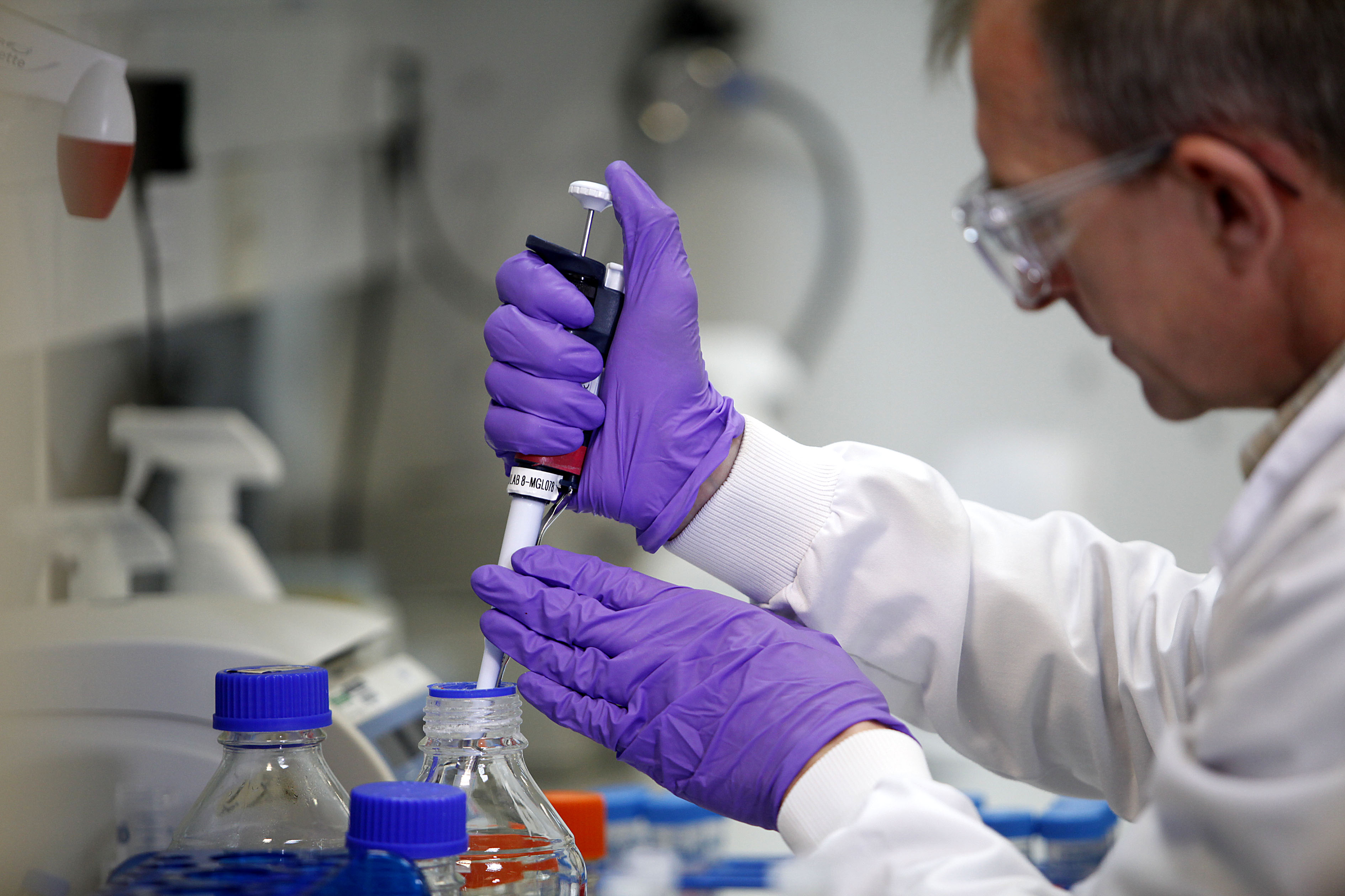Scientist using pipette in lab.