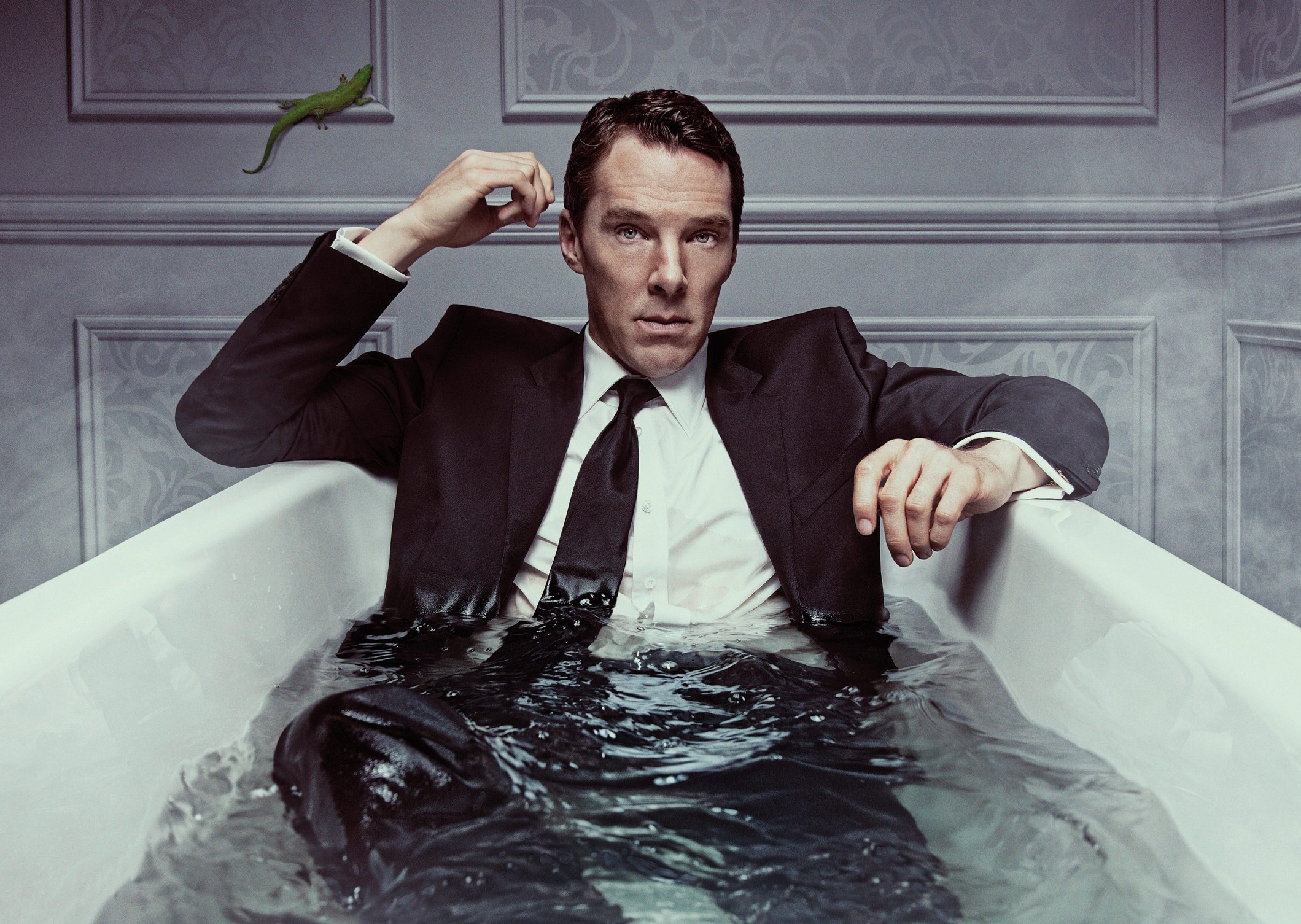 Man in suit submerged in bathtub.