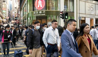 Office workers cross a street in Central, a major financial district in Hong Kong, on Jan 15, 2024. About 55,000 Chinese from the mainland have joined Hong Kong’s working masses through a “top talent” visa program since December 2022. (Anthony Kwan/The New York Times)