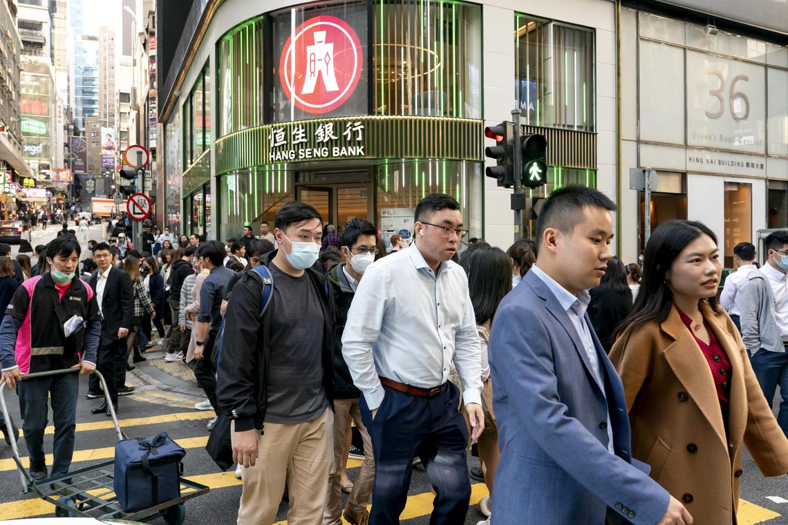Office workers cross a street in Central, a major financial district in Hong Kong, on Jan 15, 2024. About 55,000 Chinese from the mainland have joined Hong Kong’s working masses through a “top talent” visa program since December 2022. (Anthony Kwan/The New York Times)