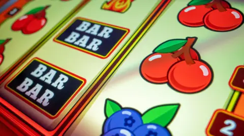 Getty Images A close-up of the icons on a fruit machine, including "Bar" and cherry icons.