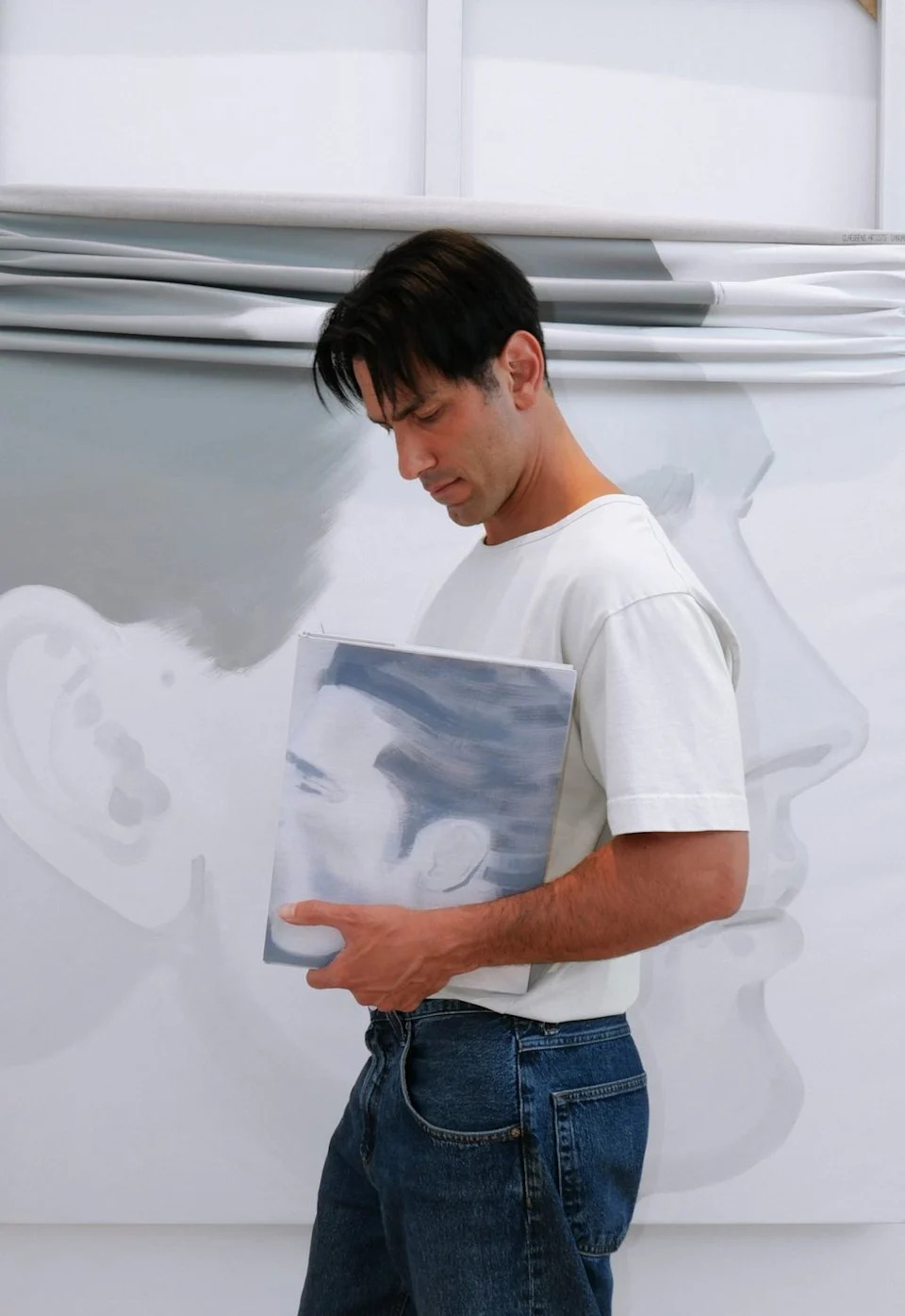 Jwan Yosef poses for a photograph holding his book Intimacies