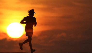 FILE - A jogger is silhouetted while running on a jetty at sunrise over the Atlantic Ocean in Bal Harbour, Fla., on Sept. 19, 2020. (AP Photo/Wilfredo Lee, File)