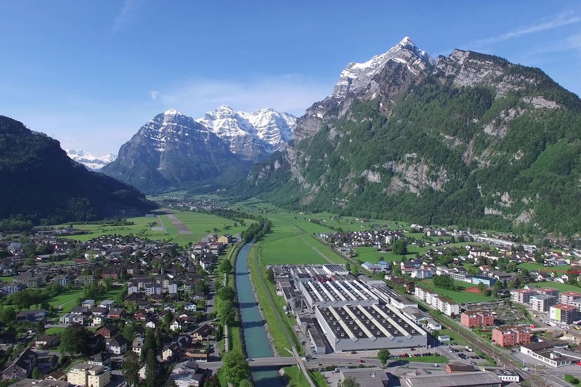 An aerial view of Netstal, a 550-employee company located in Glarus, Switzerland. Specialising in injection moulding machines to make drink bottles and plastic packaging, it is part of Switzerland's "Kamus" or small and medium enterprises finding ways to adapt to the 39% US tariff.