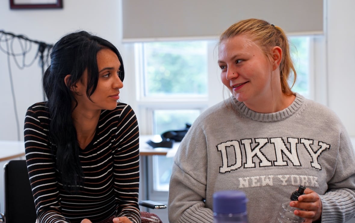 Two people sit and look at each other. 