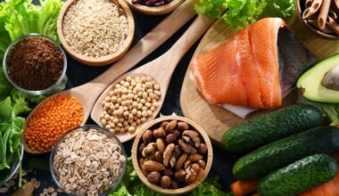 A table with healthy foods like salmon, wholegrains, vegetables, nuts and beans.