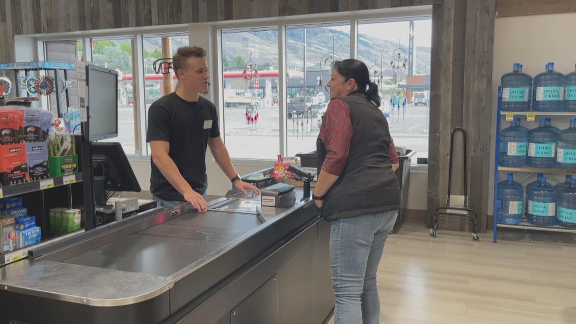 A young man helps someone in a grocery store