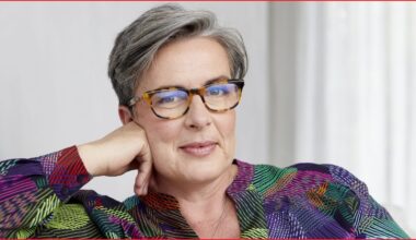 A close up of a middle-aged woman with short-ish hair wearing glasses and smiling slightly.