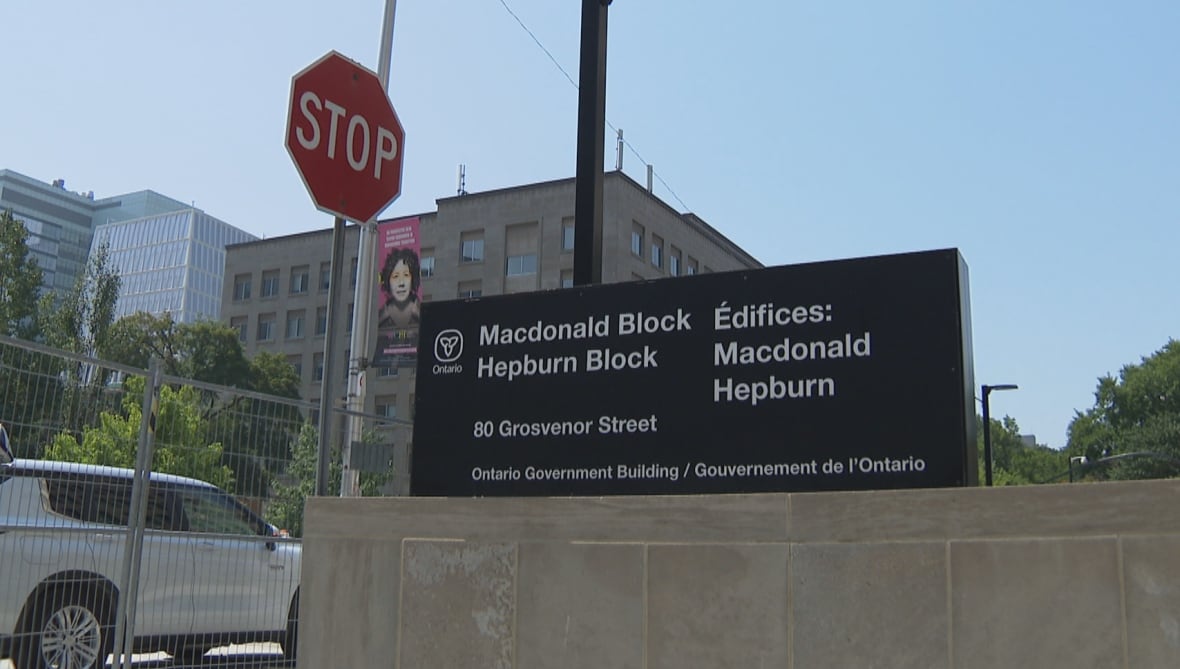 Sign with Ontario provincial logo and the words Macdonald Block, Hepburn Block, 80 Grosevnor Street, Ontario Government Building. 