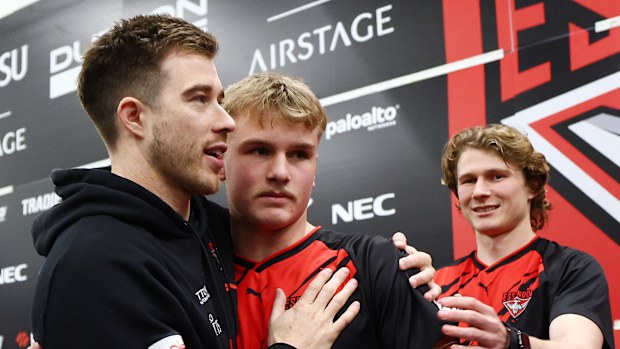 Zach Merrett of the Bombers congratulates Oskar Smartt on his debut.