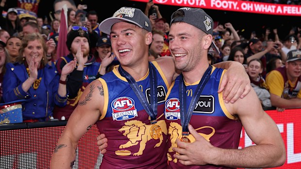 Lions teammates Cam Rayner and Josh Dunkley embrace while celebrating their AFL grand final win.