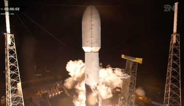 a camera mounted on a nearby tower captures the head-on view of a rocket as it begins to lift off the launch pad into the night sky.