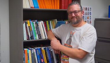 Stentor Danielson standing next to a bookshelf