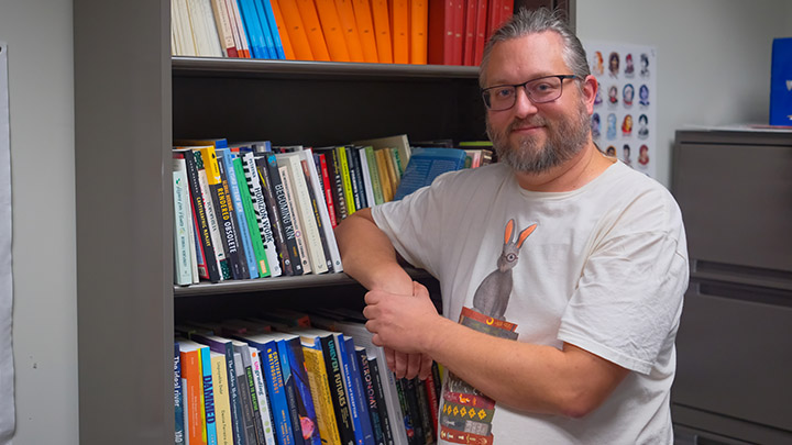 Stentor Danielson standing next to a bookshelf
