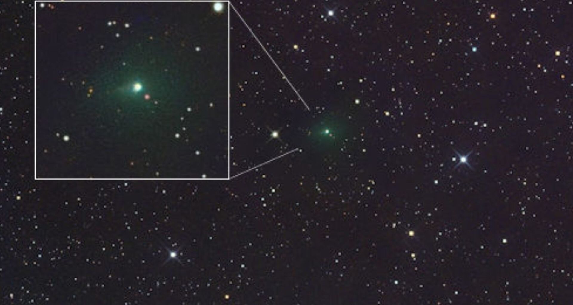 A glowing green light is seen in the center of a starry image from space but also in a white cutout box on the left part of the image