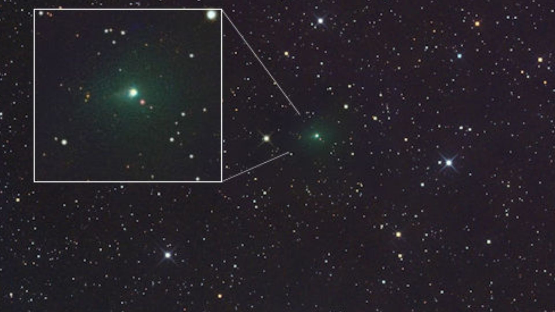 A glowing green light is seen in the center of a starry image from space but also in a white cutout box on the left part of the image