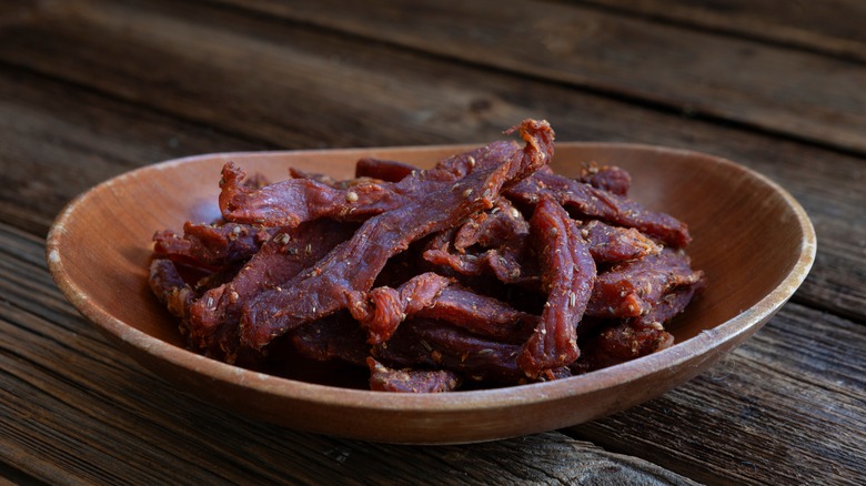 Thin pieces of beef jerky in a wooden bowl