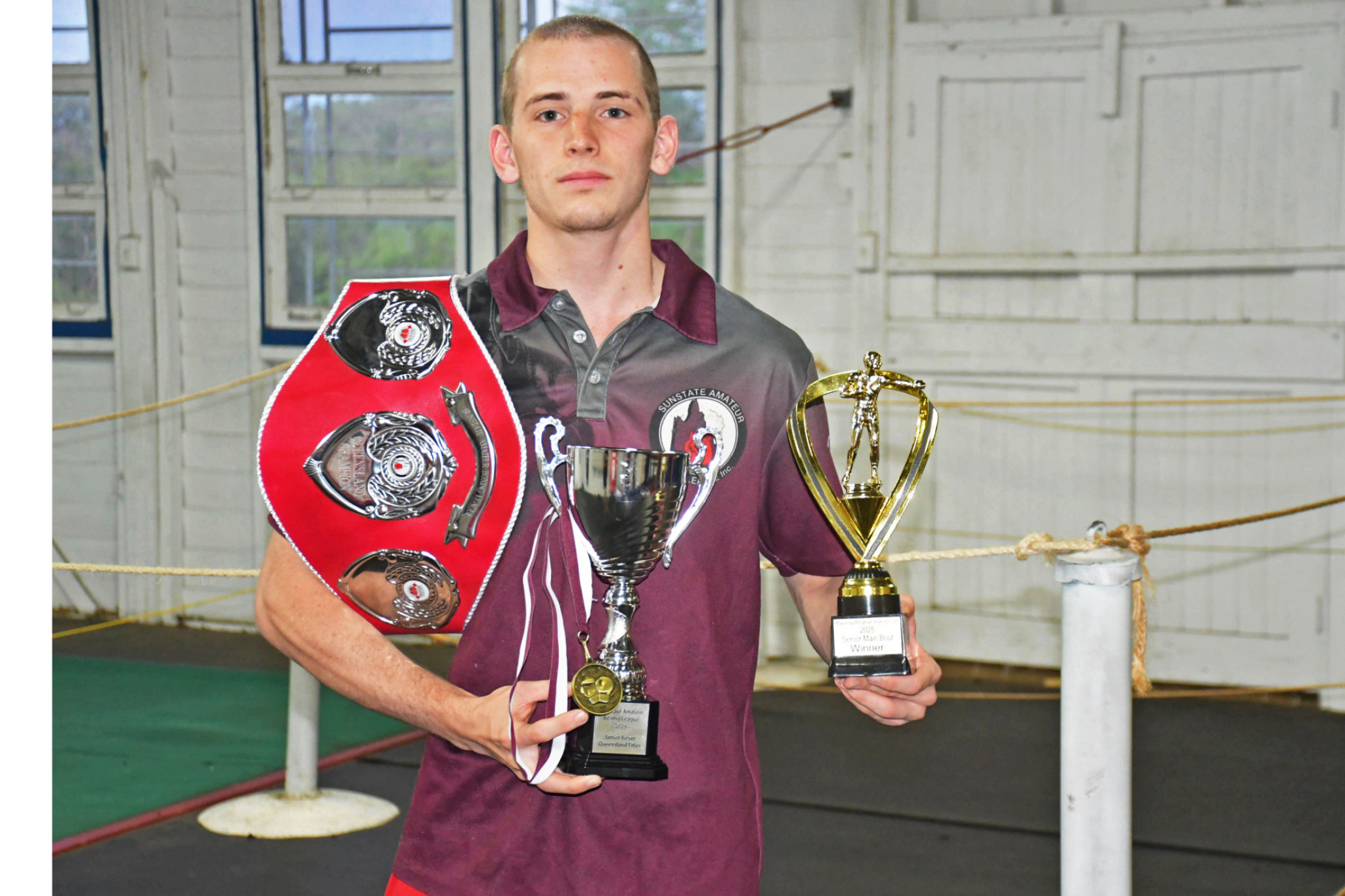 Team Mareeba Boxing fighter Matt Carroll holding his Queensland Champion belt, lightweight champion medal, and Senior Boxer of the Tournament trophy from the State Titles – as well as his main bout winner trophy (right) from a recent Mareeba fight.