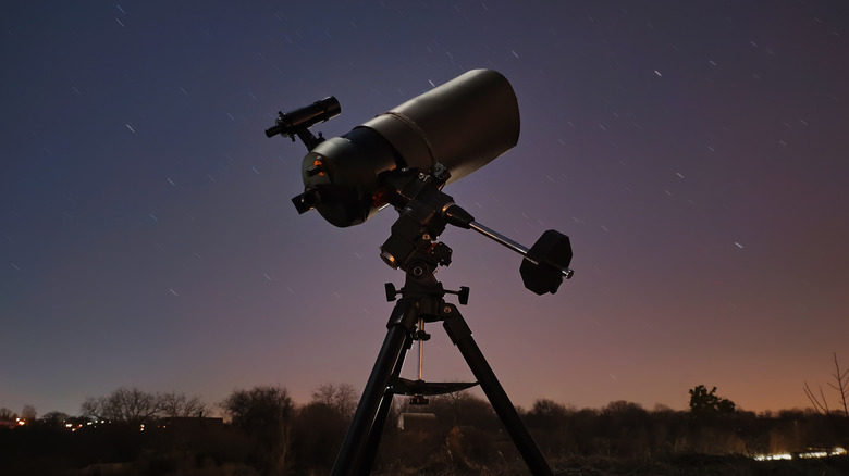 Telescope pointed at starry night sky