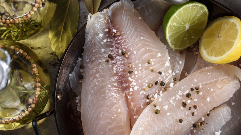 Two raw fish filets with citrus on the side