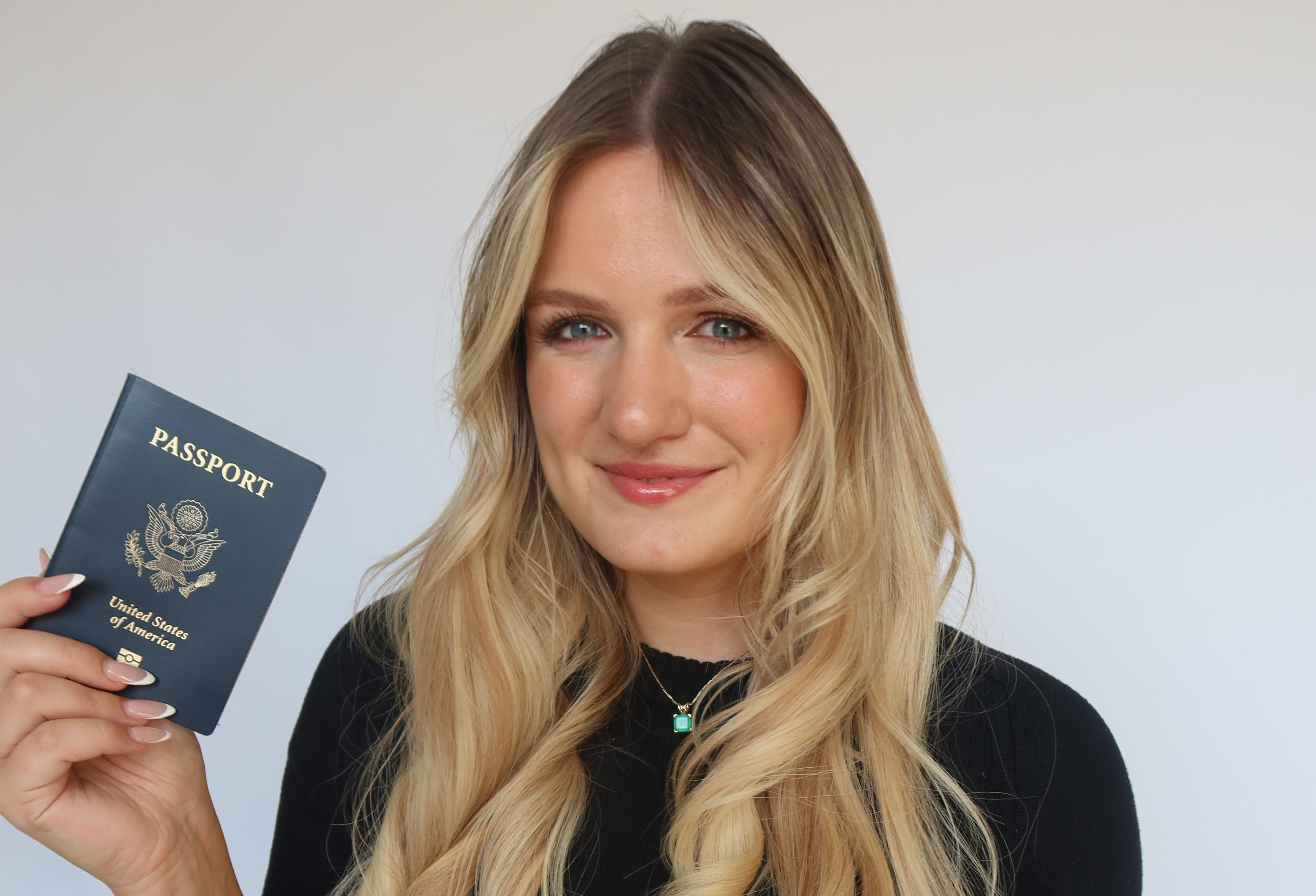 Madison Rolley, American travel influencer, holding a United States passport.