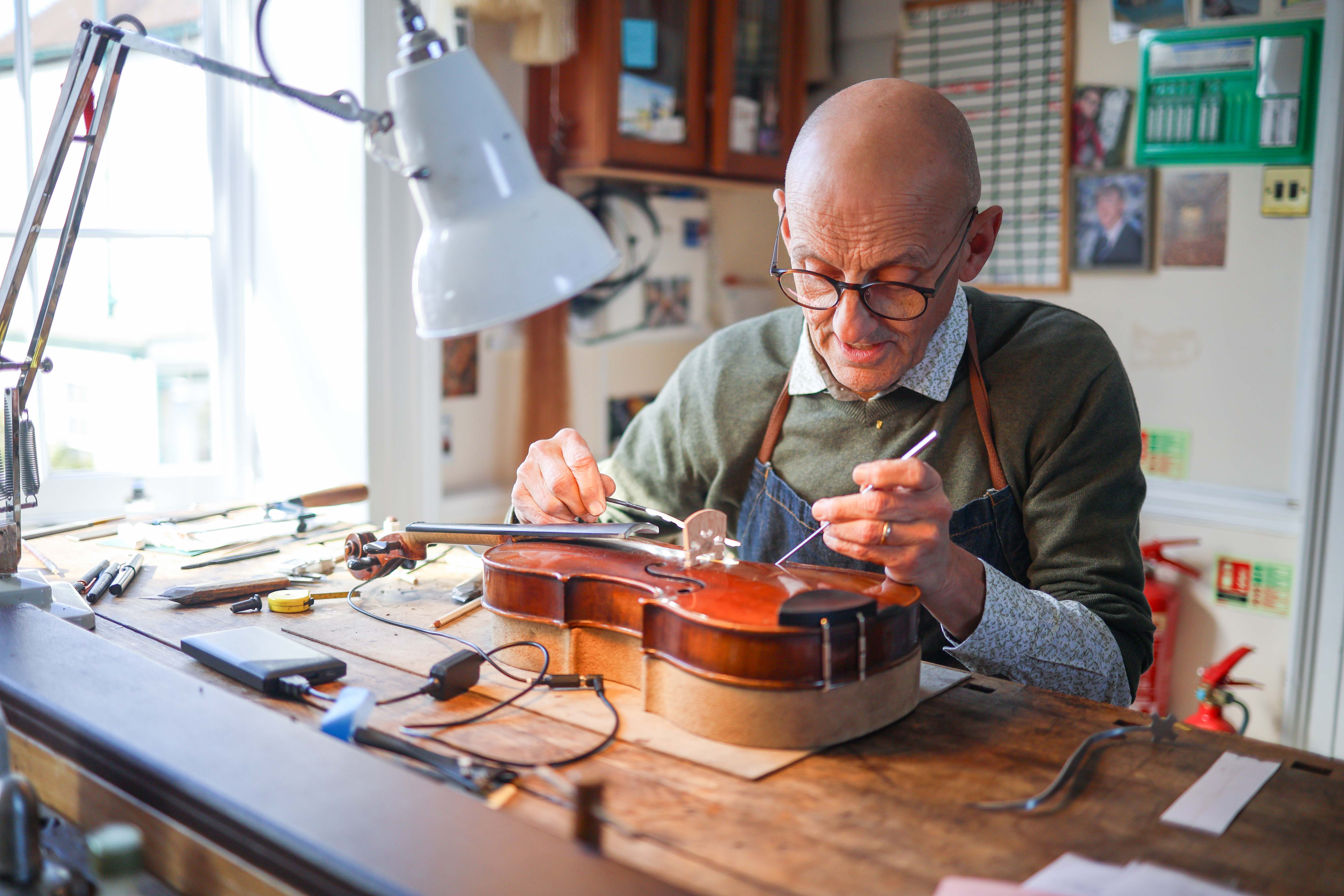 Philip Brown, a violin maker, inspecting a violin.