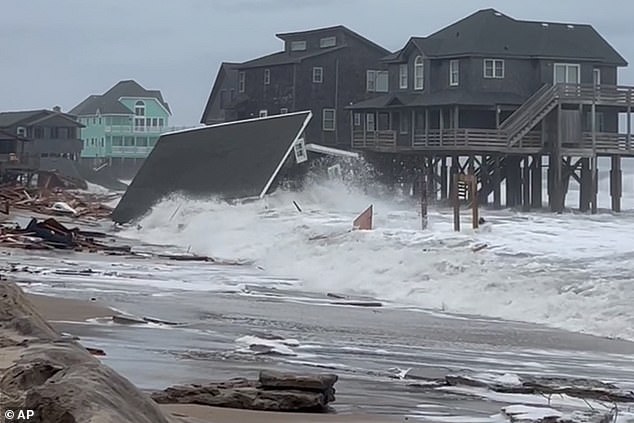 Waves from Hurricanes Humberto and Imelda hit a home in Buxton, North Carolina, yesterday