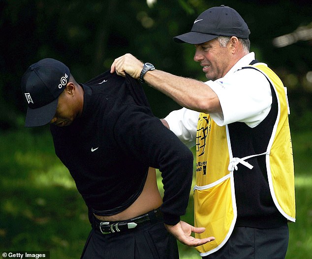 Woods is pictured getting creamed rubbed onto his back by former caddie Steve Williams during the American Express Championship in Ireland in 2004
