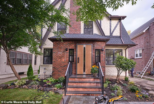 The home's exterior features a sleek metal door, replacing the old, weather-worn wooden one, new windows and tiled pathway