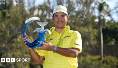 Hideki Matsuyama holding The Sentry trophy.