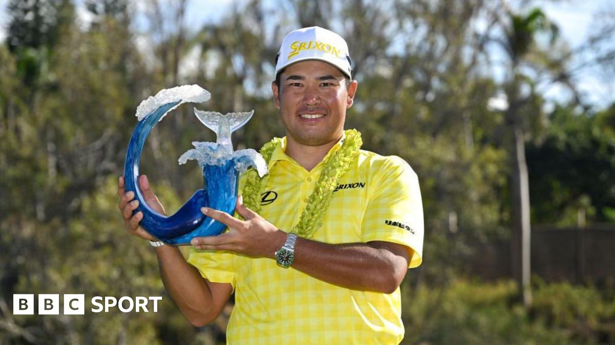 Hideki Matsuyama holding The Sentry trophy.