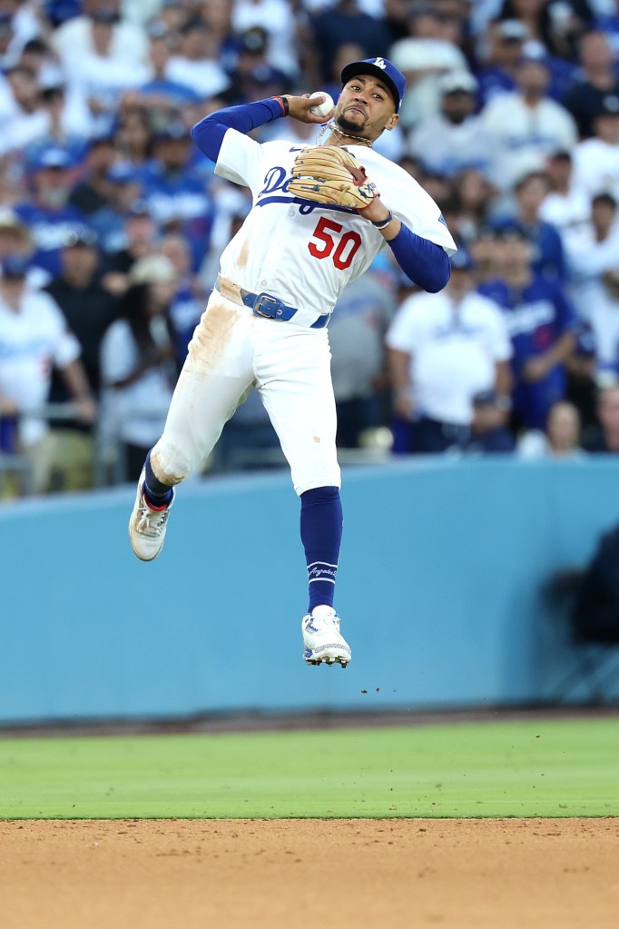 Mookie Betts jumps in the air and throws to first base