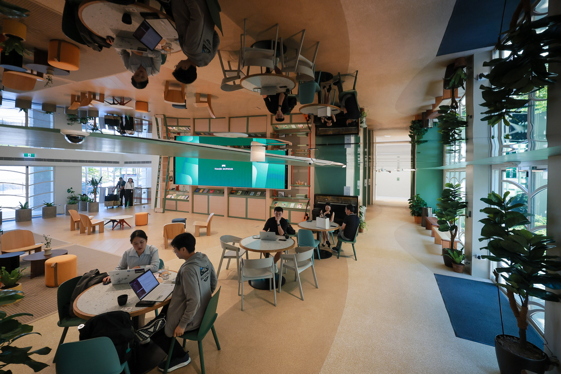 A walkway with a mirrored ceiling connects the interior spaces of the newly renovated Temasek Shophouse.
