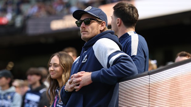 Tom Stewart watches from the sidelines ahead of the AFL grand final clash against the Brisbane Lions, unable to take his place on the field.