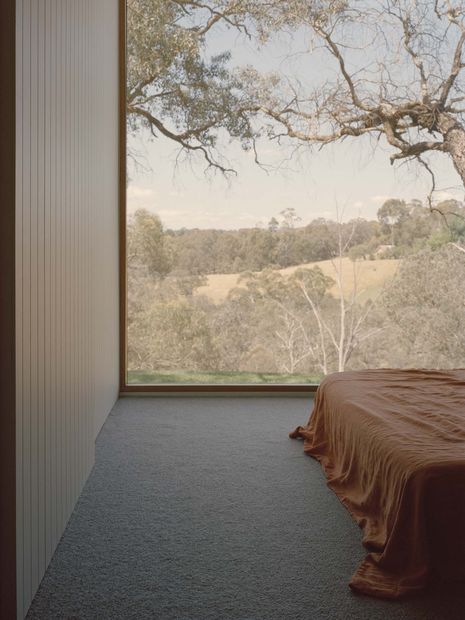 A full wall of glazing frames the landscape in the main bedroom.