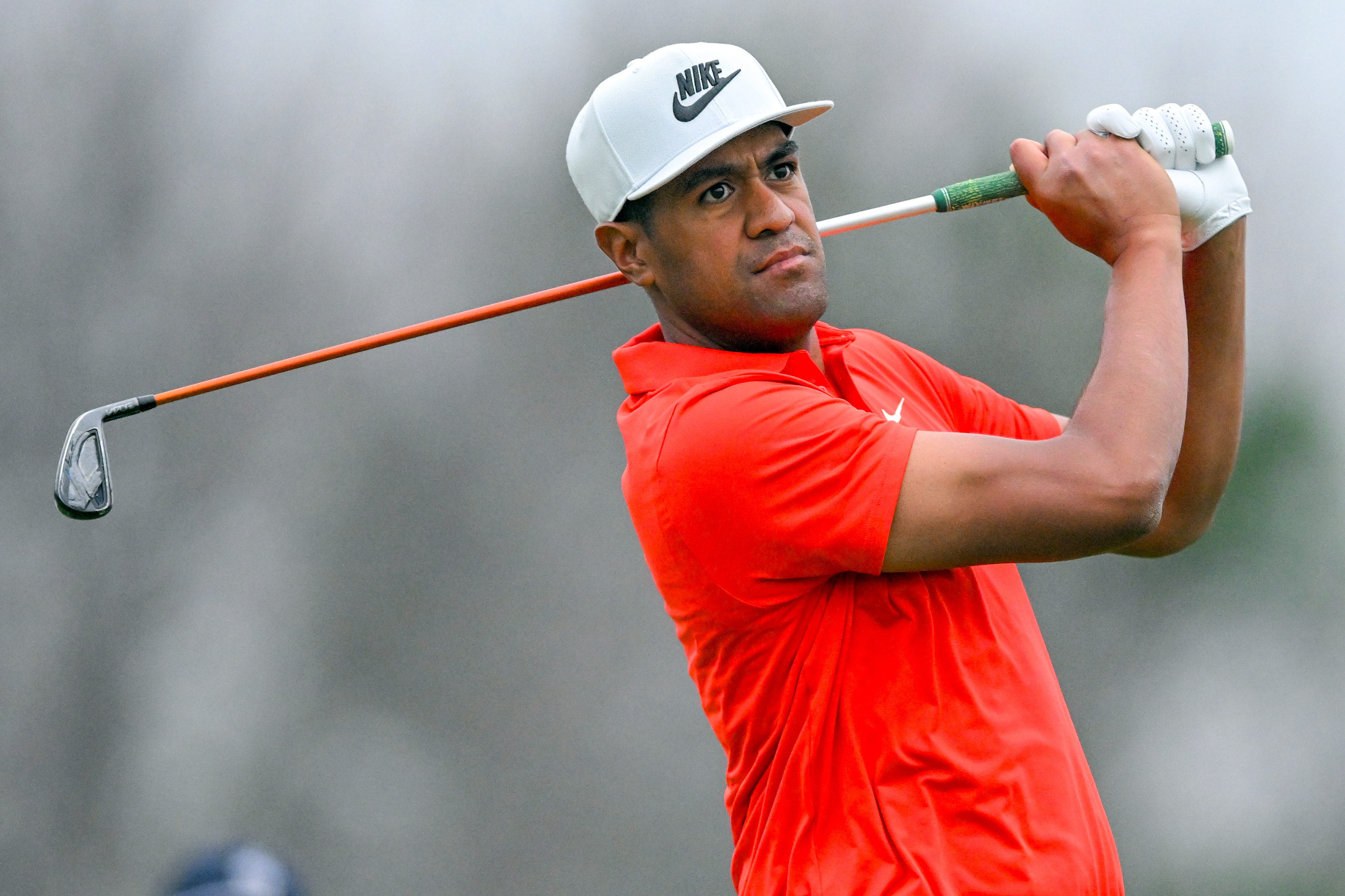 Tony Finau hits an iron and watches its flight