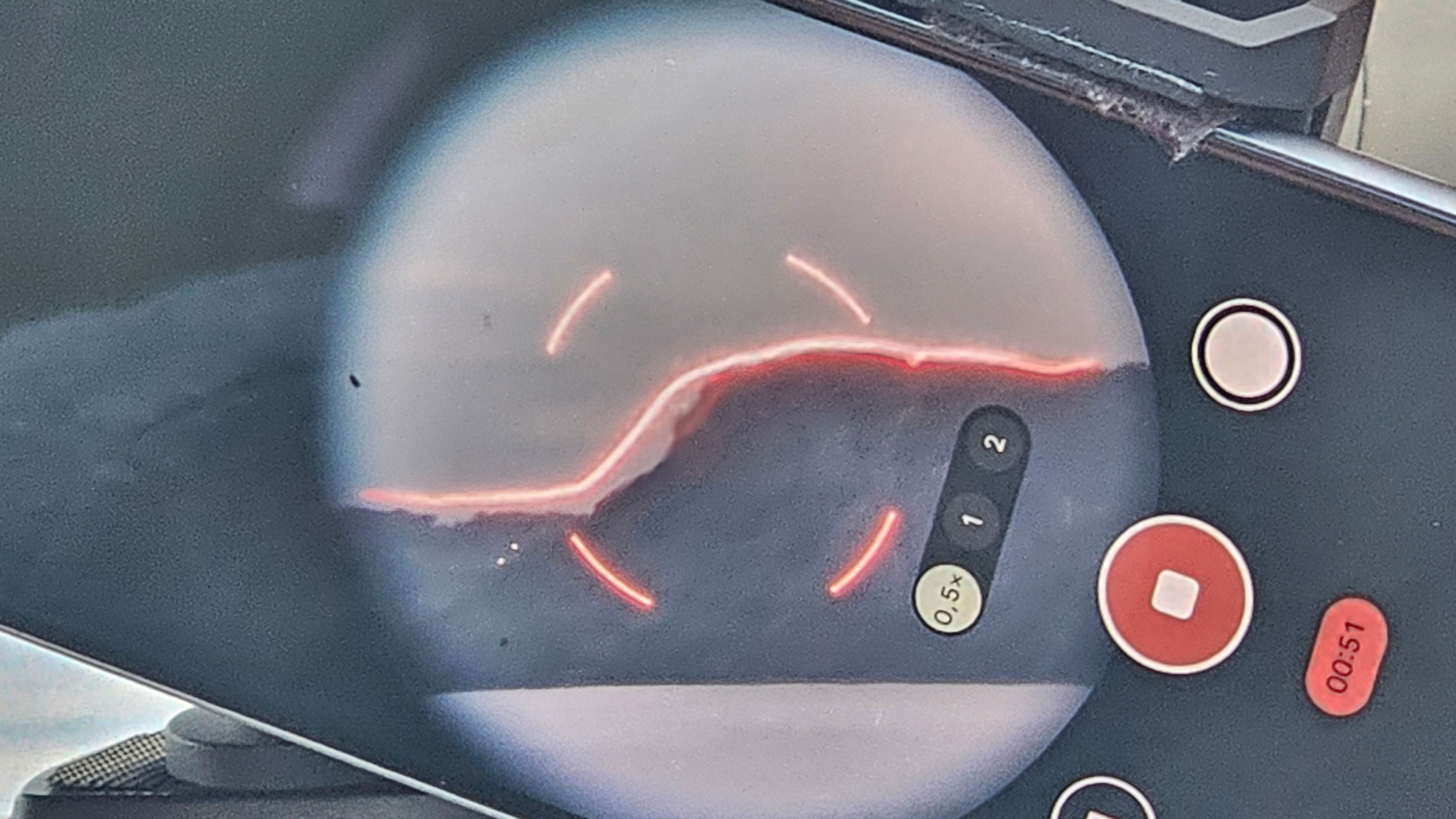 A smartphone showing the view through the Unistellar Envision binoculars with a red AR overlay of a mountain.