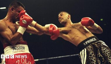 A boxer in red trunks labelled "Vazquez" taking a punch to the face from an opponent in leopard-print trunks labelled "Prince" during a match in a boxing ring.