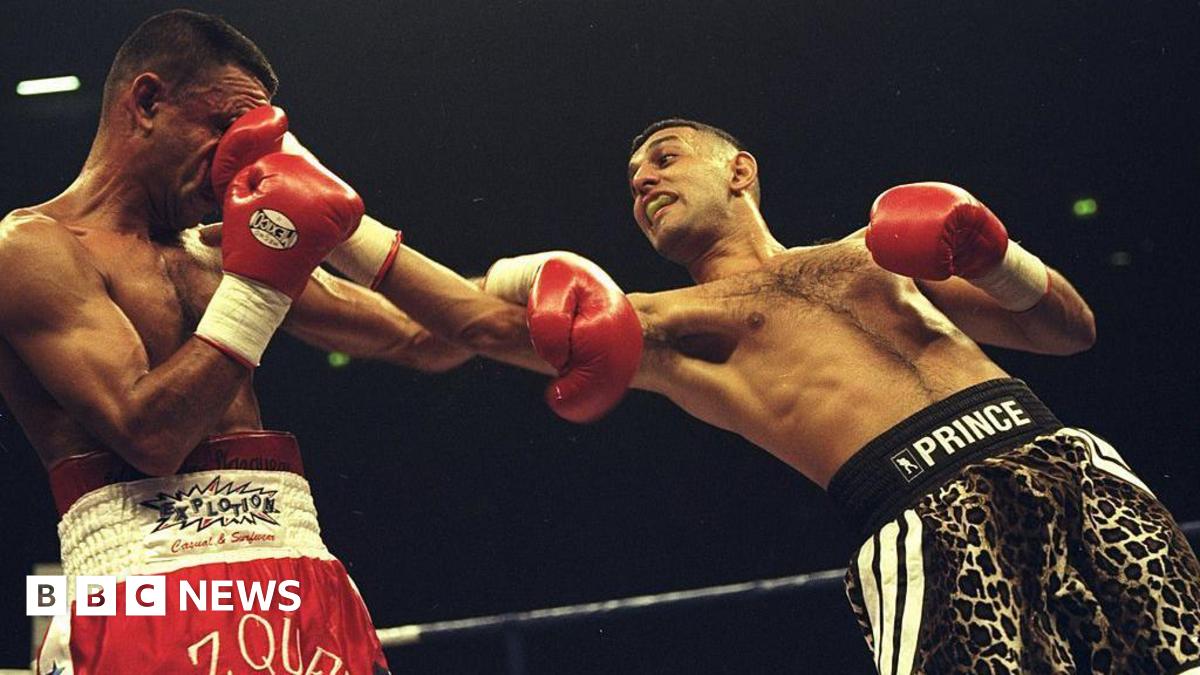 A boxer in red trunks labelled "Vazquez" taking a punch to the face from an opponent in leopard-print trunks labelled "Prince" during a match in a boxing ring.