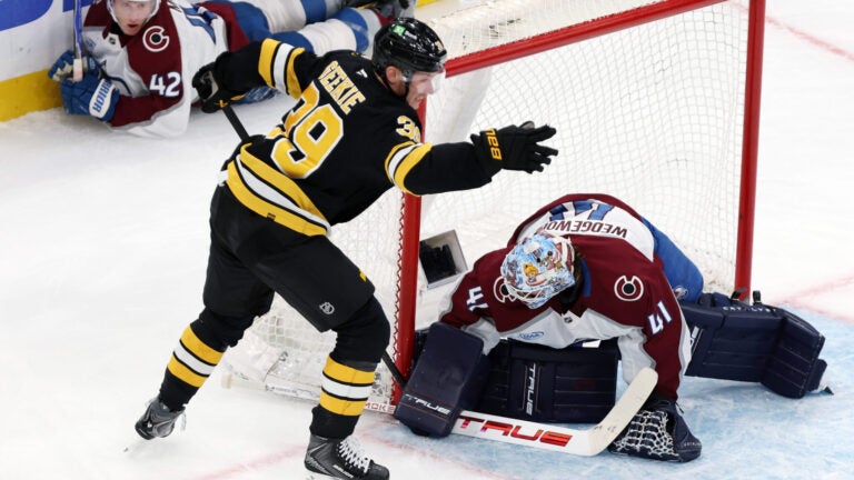 Boston Bruins forward Morgan Geekie reacts after stuffing the puck past Colorado Avalanche goalie Scott Wedgewood to score with five seconds remaining in the second period as Colorado defenseman Josh Manson watches in the background during a hockey game, Oct. 25, 2025, in Boston.